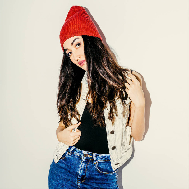 Brunette Model in fashion beanie cap and jeans. Urban casual sty - 写真・画像