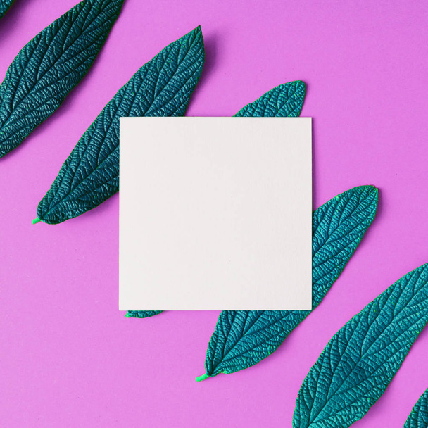 weiße leere Papierkarte mit grünen Blättern auf violettem Hintergrund, minimales Sommerkonzept  - Foto, Bild