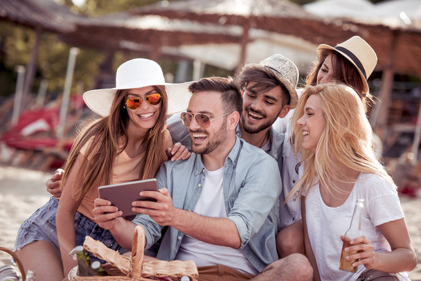 groep jonge vrienden nemen selfie met tablet op strand - Foto, afbeelding