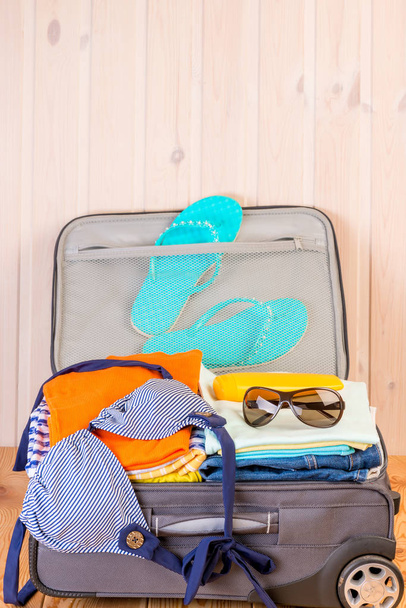 pequeña maleta de peluche con cosas de mujer para unas vacaciones en el mar
  - Foto, Imagen