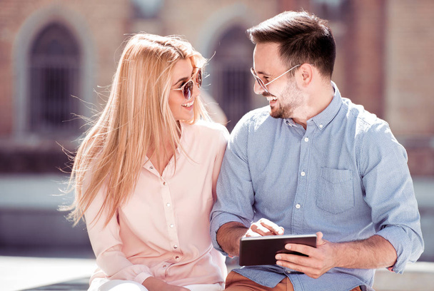 νεαρό ζευγάρι έχει τη διασκέδαση και τη χρήση tablet σε εξωτερικούς χώρους  - Φωτογραφία, εικόνα
