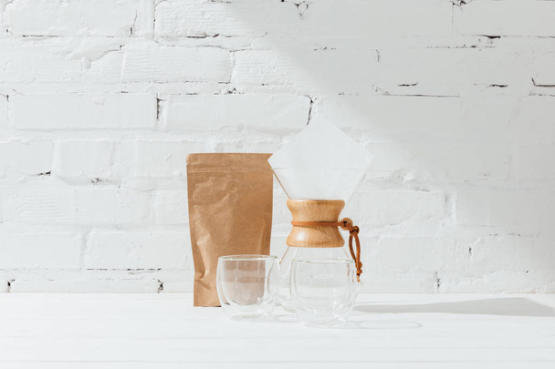 Glass mugs, chemex and paper package with coffee  - Фото, зображення