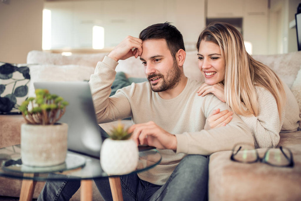 Young couple relaxing on sofa with laptop - Photo, Image