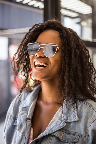 Johannesburg, South Africa, January 10, 2018: Girl smiling with Afro hairstyle and sunglasses.  - Фото, изображение