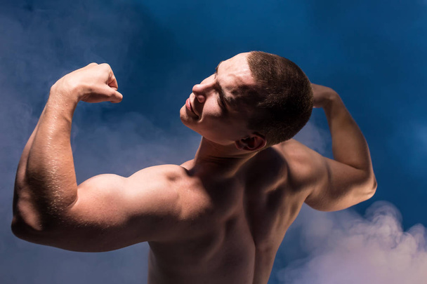 Young man shows muscles - Photo, Image