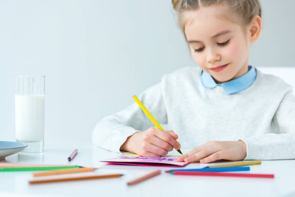 portrait of kid drawing greeting postcard for mother with colorful pencils at table, mothers day holiday concept  - Photo, Image