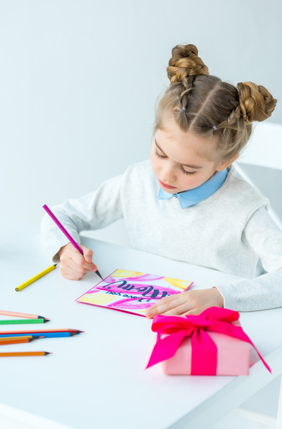 portrait of kid drawing greeting postcard for mother with colorful pencils at table, mothers day holiday concept  - Foto, Bild