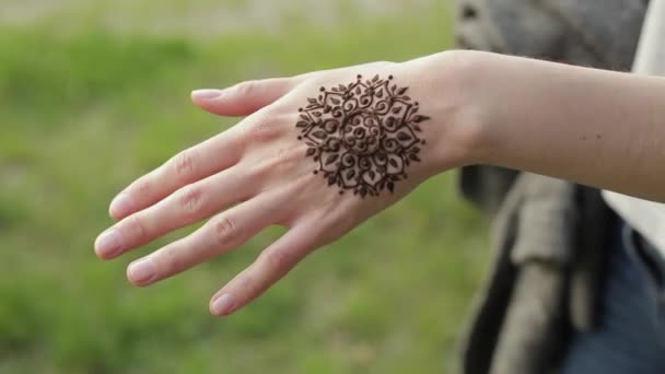 Primer plano de la mano femenina con tatuaje de henna. Chica bonita mostrando su nuevo mehendi floral a la cámara
. - Imágenes, Vídeo