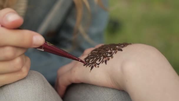 Молода жінка робить квітковий мехенді на руці за допомогою хни
. - Кадри, відео
