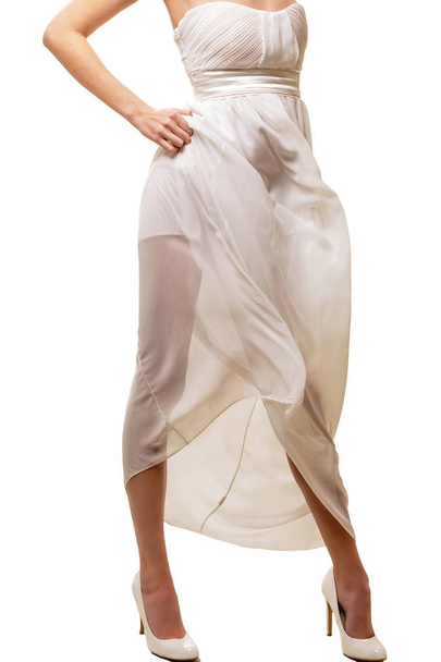 Pernas femininas em um vestido branco
 - Foto, Imagem