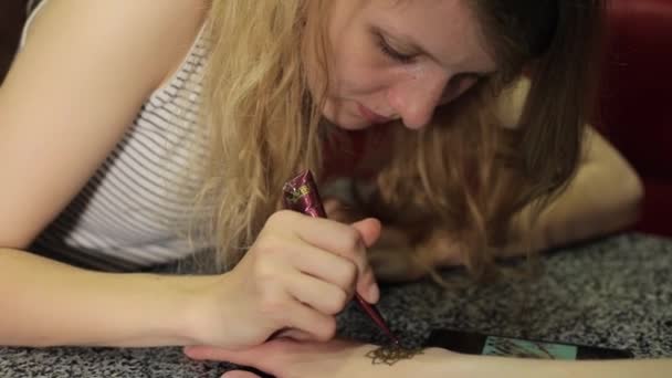 Frau macht florale mehendi auf einer Hand mit Henna auf einem Tisch. - Filmmaterial, Video