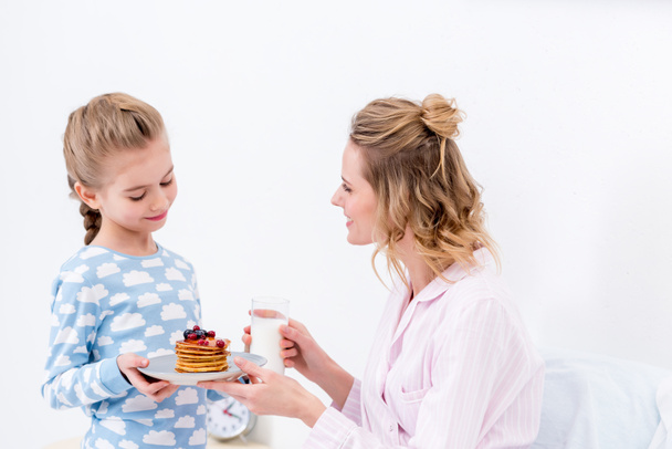 daughter giving mother pancakes on happy mothers day - Фото, зображення