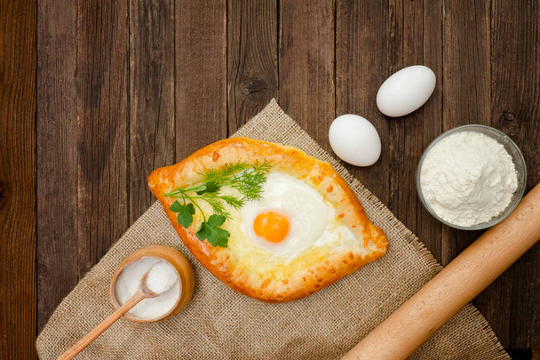 Χατσαπούρι με αυγά σε λινάτσα, αλάτι, αλεύρι και αυγά. Ξύλινο τραπέζι - Φωτογραφία, εικόνα