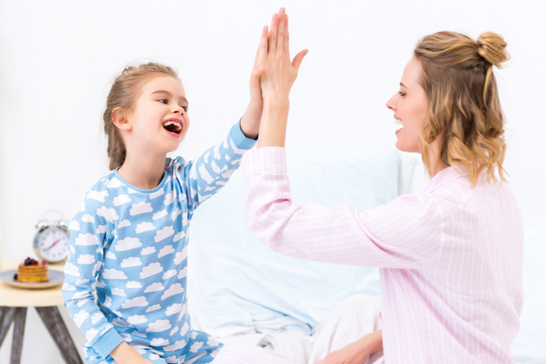 mother and daughter giving high five at home - Fotografie, Obrázek