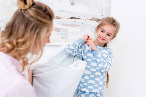 mother and daughter having fun and fighting with pillows at home  - Fotoğraf, Görsel