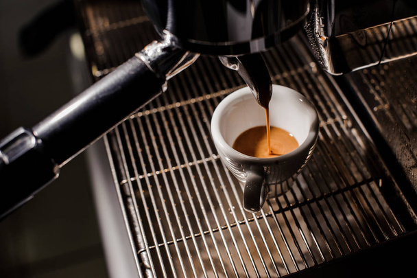 White ceramic cup of espresso in the coffee mahine - Фото, зображення