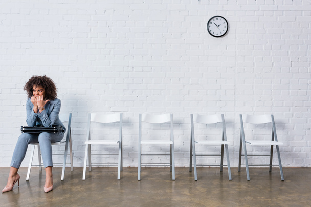 Nerveus vrouwelijke kandidaat met werkmap wachten op gesprek - Foto, afbeelding