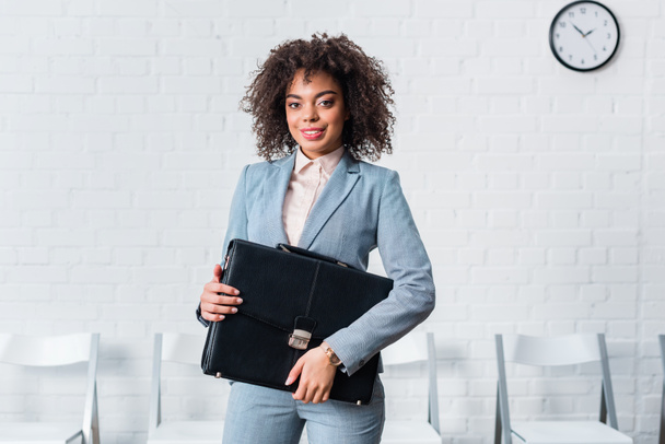 African american businesswoman in suit holding briefcase - Fotografie, Obrázek