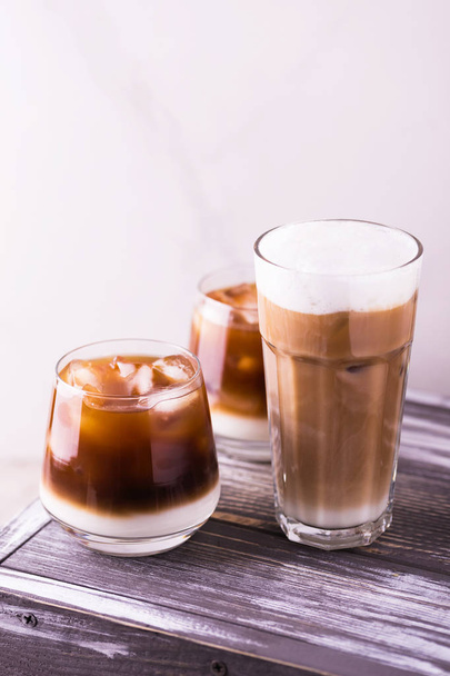Iced coffee in glasses with milk. Black background - Valokuva, kuva