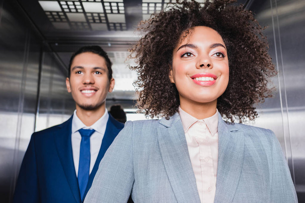 Des hommes d'affaires afro-américains souriants dans un ascenseur
 - Photo, image