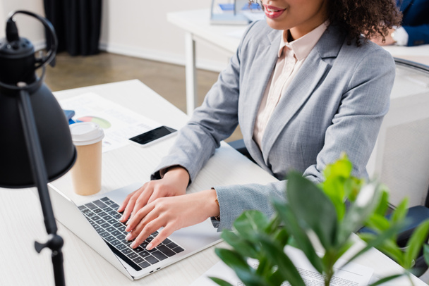 Visão de close-up da mulher digitando no teclado do laptop por mesa de escritório
 - Foto, Imagem