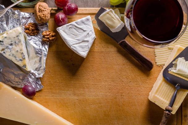 Paleta de muchos tipos de queso y algunas uvas, aceitunas y vino con espacio para copiar
. - Foto, Imagen