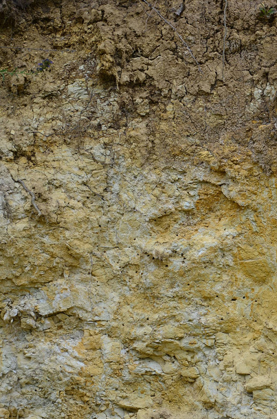 Structuur van een muur van solide geel en bruin zand in een zanderige steengroeve - Foto, afbeelding