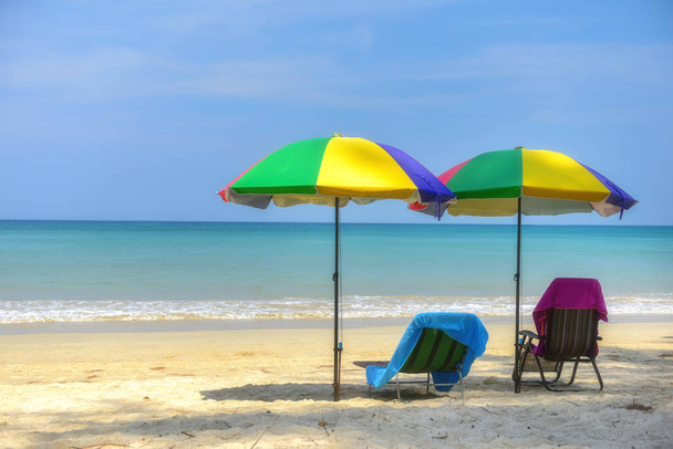 Chaise de plage sous parasol coloré sur fond de plage tropicale, concept d'heure d'été
 - Photo, image