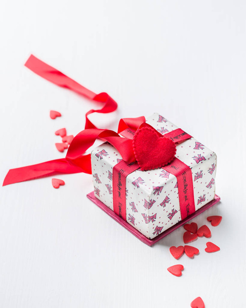 Pudełko z czerwoną wstążką i słodkimi sercami cukierków na czarnym betonowym tle. Piękne Walentynki. Romantyczny nastrój.)  - Zdjęcie, obraz