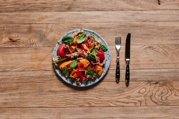 vista superior de la ensalada gourmet con mejillones, verduras y jamón en la mesa de madera
 - Foto, imagen