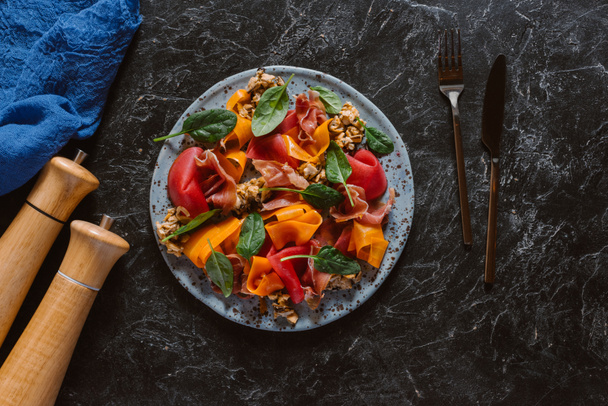 το Top view νόστιμη σαλάτα με μύδια, λαχανικά και jamon σε μαύρο   - Φωτογραφία, εικόνα