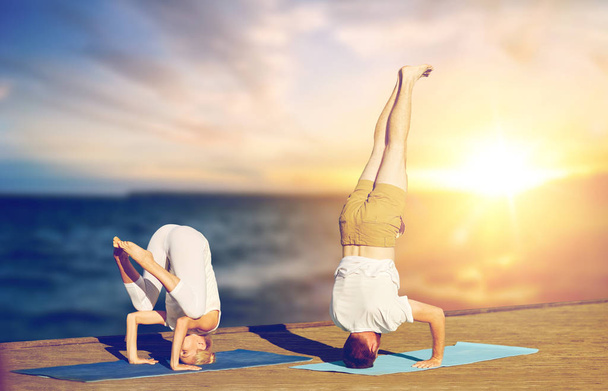 couple doing yoga headstand outdoors - Photo, Image
