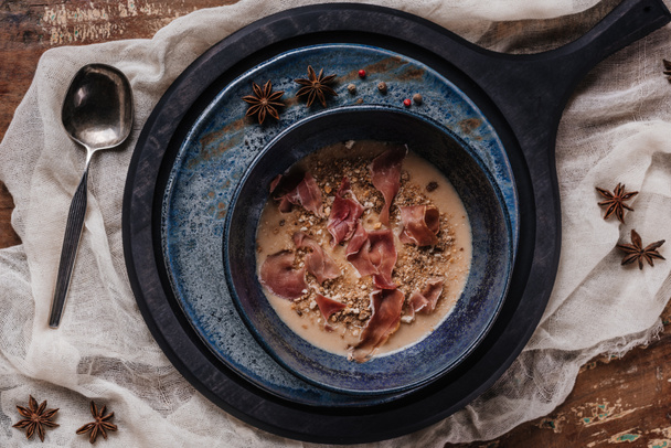 top view of delicious cream soup with fried potatoes and jamon  - 写真・画像