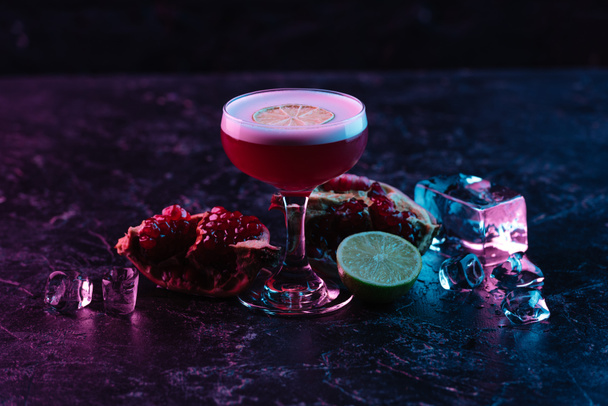 Nahaufnahme von Glas mit Conchita-Cocktail und Zutaten auf dunkler Oberfläche  - Foto, Bild