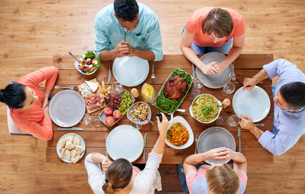 group of people eating at table with food - Foto, Imagen