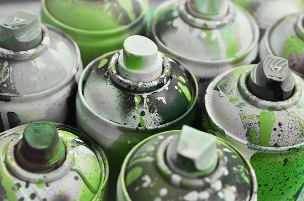 A lot of used spray cans of paint close-up. Dirty and smeared cans for drawing graffiti. The concept of a sweeping and careless drawing of paint. Creative art image - Photo, Image