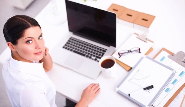 Portrait of a businesswoman sitting at  desk with  laptop - Zdjęcie, obraz