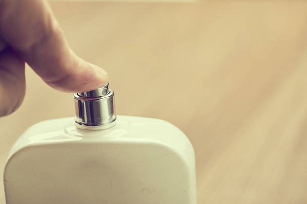 male hand holding cosmetic bottle for perfume - 写真・画像