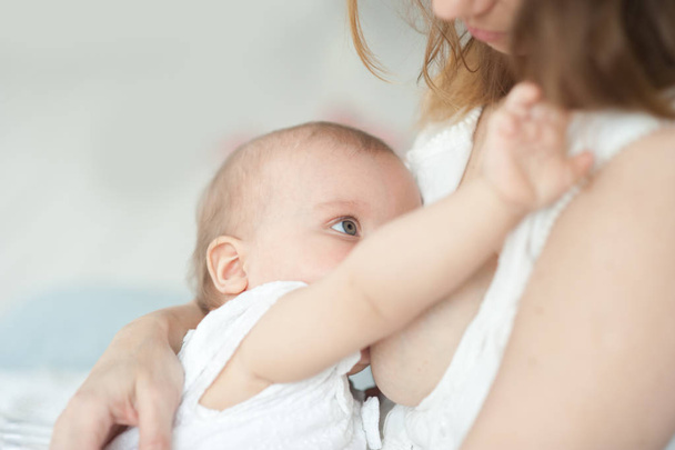 Baby eating mother's milk. Mother breastfeeding baby. - Фото, изображение