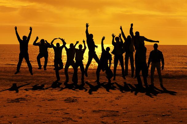 Male friends are having fun and jumping up on the sunset - Photo, Image