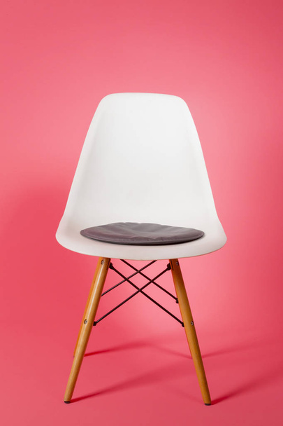 White plastic chair on pink background - 写真・画像