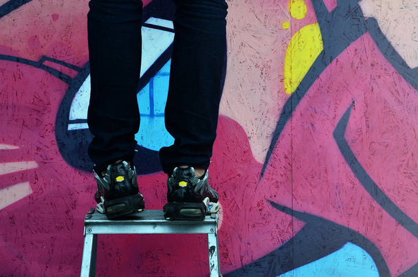Un giovane graffitista dipinge un nuovo graffito sul muro. Foto del processo di disegno di un graffito su un muro primo piano. Il concetto di street art e vandalismo illegale
 - Foto, immagini