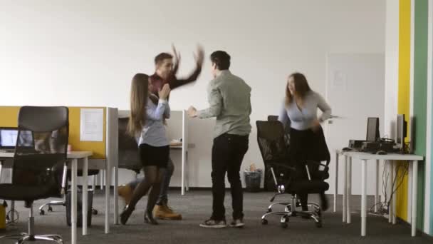 Fiatal irodai dolgozó birtoklás egy szerencsés nap, nem tud állni, tánc. Mindenki az irodában boldog vele. - Felvétel, videó