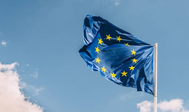 Σημαία της Ευρωπαϊκής Ένωσης ΕΕ ενάντια σε ένα καταγάλανο ουρανό. Σύντομα θα υπάρξει ένα αστέρι λιγότερο δεδομένου ότι το Ηνωμένο Βασίλειο ψήφισε να εγκαταλείψουν την ΕΕ για το 2016, - Φωτογραφία, εικόνα