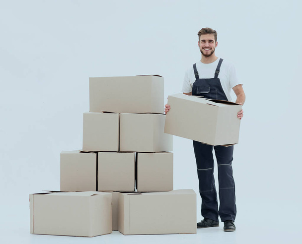 Young man carrying a box to the pile of boxes. - Photo, image