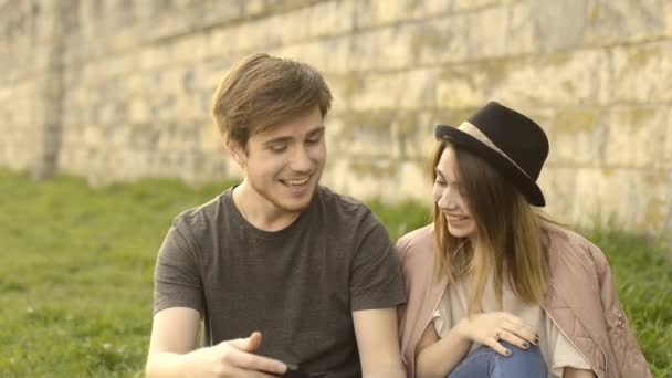 Un chico joven y una chica miran en la tableta y sonríen
 - Imágenes, Vídeo
