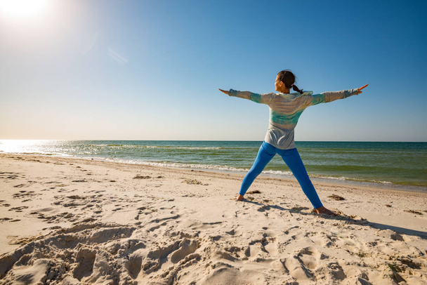 Woman practice yoga on the seashore - Zdjęcie, obraz
