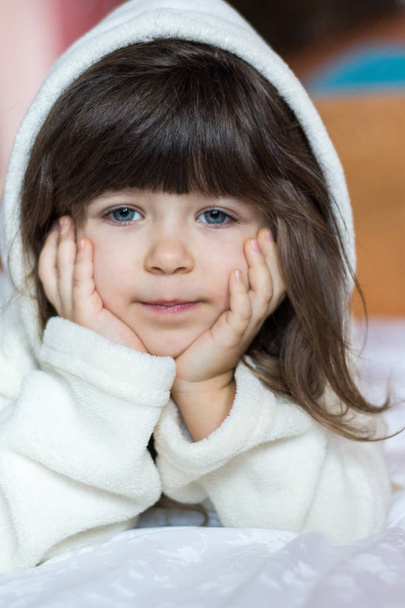 Banyo sonra gülümseyerek bornoz giyen sevimli küçük kız portresi - Fotoğraf, Görsel