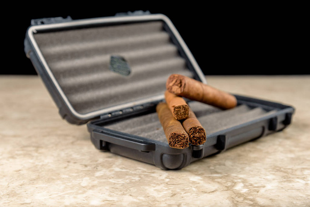 Sigaren op de top van een zwarte reis humidor. Rijke ruiken en textu - Foto, afbeelding