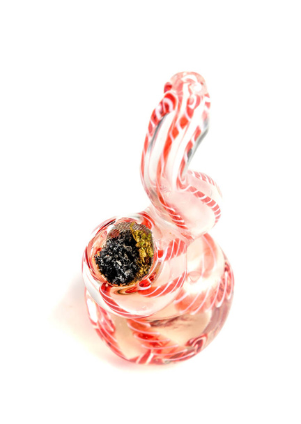 Nahaufnahme medizinischer Marihuana-Knospen mit einem Glasrohr - Foto, Bild